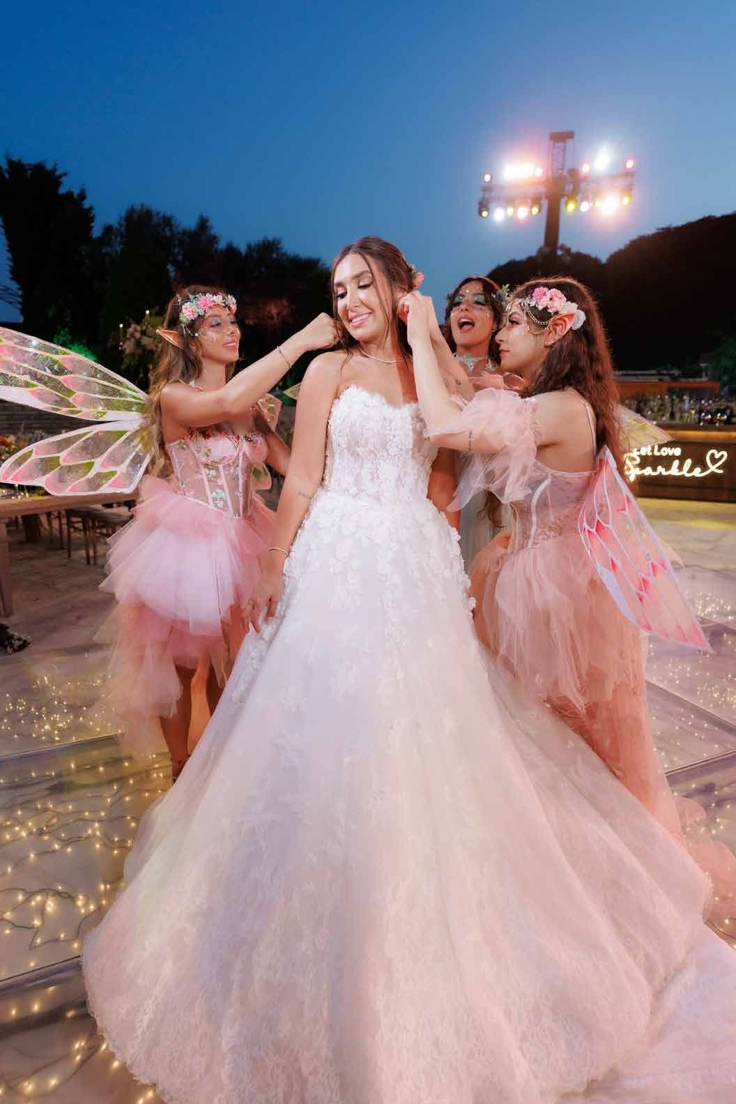 Bride laughing with her bridesmaids dressed as fairies