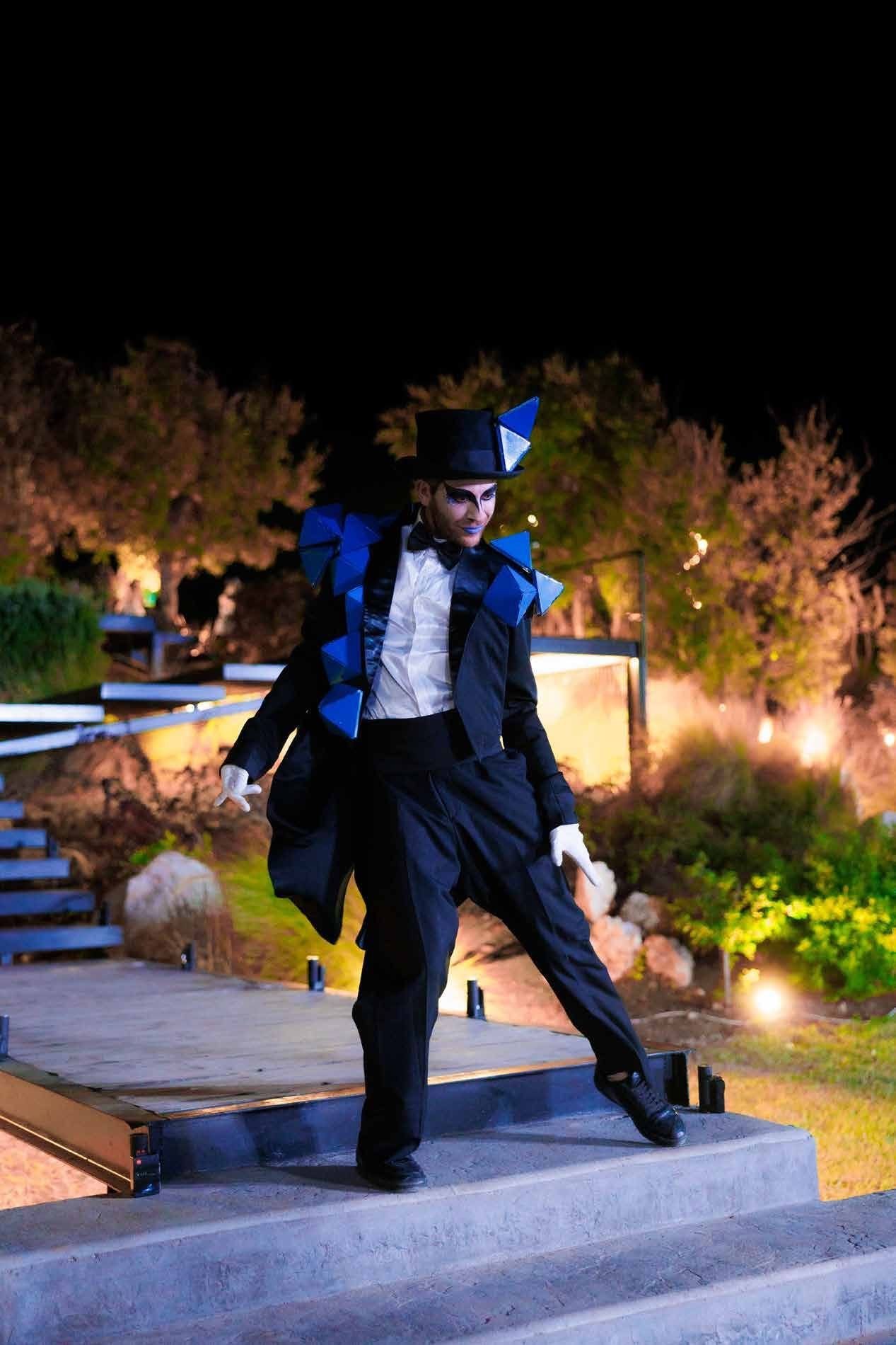 Entertainer in a striking blue geometric costume greeting guests