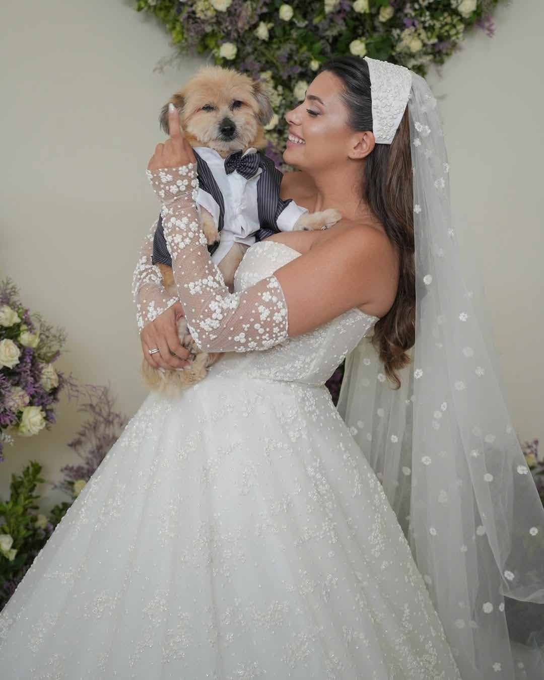 Bride embracing her dog in her wedding gown